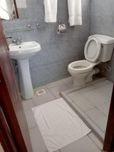 a bathroom with a toilet and a sink at Diani Breeze Villas in Diani Beach