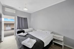 a bedroom with a large bed and a large window at Ned Kelly's Motel in Maryborough