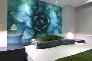 a bedroom with a bed with a blue wall at HOTEL A La Mode -アラモード- in Utazu