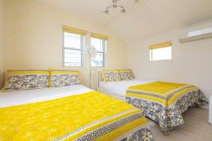 a bedroom with two beds and two windows at 舞浜1軒家貸切ー最大10名様一駐車場付きMaihama rent-a-house in Urayasu