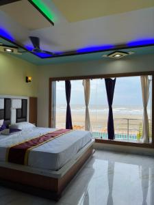 a bedroom with a bed with a view of the beach at ST Apple Beach Resort Mandarmani in Mandarmoni