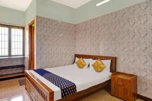 um quarto com uma cama com almofadas amarelas e azuis em OYO Flagship Sri Balaji Lodge Non Ac em Pollāchi