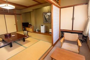 静かなお宿加賀美 في Shimojo mura: غرفة معيشة مع طاولة وغرفة طعام