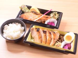 drie dienbladen met rijst en vlees op een tafel bij APA Hotel Niigata Tsubame-Sanjo Ekimae in Tsubame