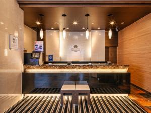 a bar with a bench in a lobby with lights at APA Hotel Niigata Tsubame-Sanjo Ekimae in Tsubame