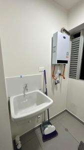 a bathroom with a sink and a water heater at Hermoso departamento de estreno con piscina in Lima