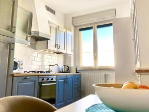 a kitchen with blue cabinets and a bowl of fruit on a table at Giovinazzo e il mare in Giovinazzo