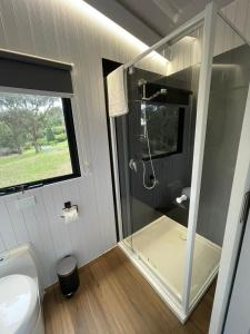 a bathroom with a glass shower and a toilet at Longmore Estate in Daylesford