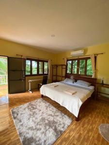 een slaapkamer met een groot bed en een tapijt bij Bungalow in the jungle in Salad Beach