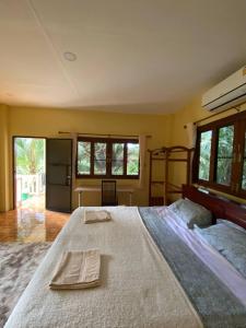 een slaapkamer met een groot bed en 2 handdoeken bij Bungalow in the jungle in Salad Beach