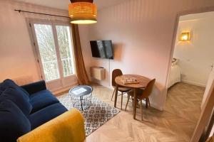 a living room with a blue couch and a table at Appartement T2 Petite Jade in Luchon