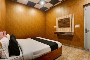 1 dormitorio con cama y ventana pequeña en OYO Hotel Kingland Water Park Rohtak, en Rohtak