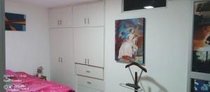 a room with white cabinets and a painting on the wall at Casa Raices in Quito