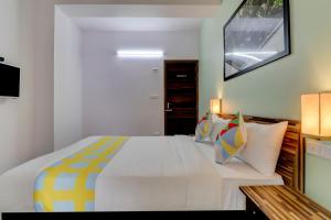 1 dormitorio con 1 cama blanca grande con almohadas coloridas en OYO Home Exotic Stay Bsk 3rd Stage, en Bangalore