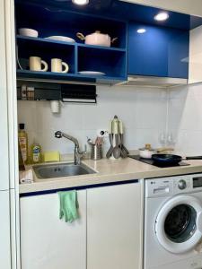 a kitchen with a sink and a washing machine at Guil Property in Seoul