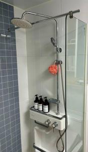 a shower with bottles on a shelf in a bathroom at Guil Property in Seoul