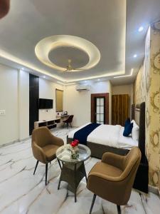 a hotel room with a bed and a table and chairs at Crescent Inn in Greater Noida