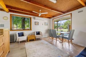 a living room with a dining room table and chairs at Kalamunda 6 - On the Rail Trail in Bright