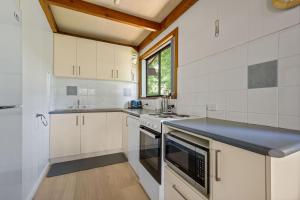 a kitchen with white cabinets and a blue counter top at Kalamunda 6 - On the Rail Trail in Bright