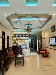 een lobby met een bank, een tafel en een tv bij khách sạn Kim Long in Ho Chi Minh-stad