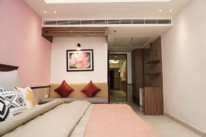 a bedroom with a bed and red pillows at HOTEL CENTRA in Mohali