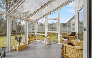 a conservatory with windows and chairs in a room at Holiday Home Nørre Nebel 9 in Nymindegab +15 photos