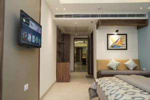 Schlafzimmer mit einem Bett und einem Flachbild-TV in der Unterkunft HOTEL CENTRA in Mohali