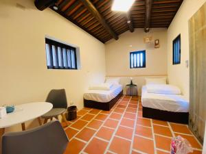 a room with two beds and a table and chairs at Wuzou Guesthouse in Jinsha