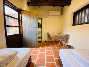 a room with two beds and a table with chairs at Wuzou Guesthouse in Jinsha