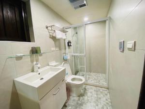 a bathroom with a toilet and a sink and a shower at Wuzou Guesthouse in Jinsha