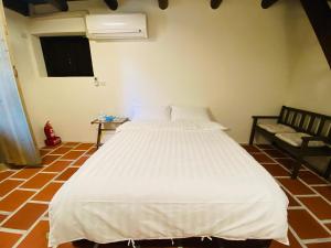 a bedroom with a large white bed and a couch at Wuzou Guesthouse in Jinsha
