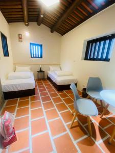 a room with two beds and a table and chairs at Wuzou Guesthouse in Jinsha
