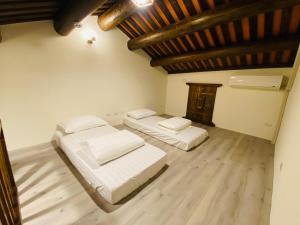 two beds in a room with a wooden ceiling at Wuzou Guesthouse in Jinsha