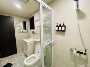 a bathroom with a toilet and a glass shower at Wuzou Guesthouse in Jinsha