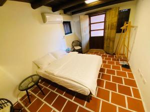 a bedroom with a bed in a brick floor at Wuzou Guesthouse in Jinsha