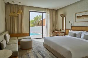 a bedroom with a large bed and a living room at ERTH Abu Dhabi Hotel in Abu Dhabi +37 photos