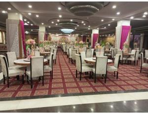 ein Esszimmer mit Tischen, Stühlen und Blumen in der Unterkunft Royal Park Resorts, Zirakpur, PB in Zirakpur