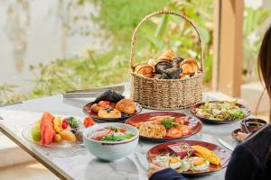 a table with plates of food and a basket of food at Banyan Tree Dongguan Songshan Lake in Dongguan