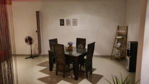 uma sala de jantar com uma mesa e cadeiras e uma ventoinha em Nebara Casa em Yogyakarta