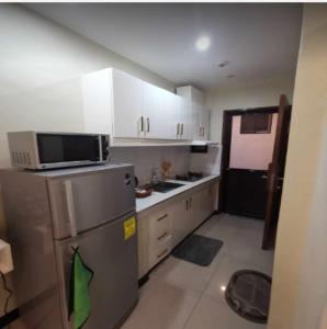 een kleine keuken met een koelkast en een magnetron bij Villa De Gracia in Manilla
