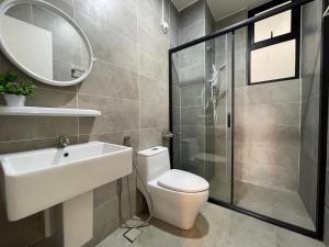 La salle de bains est pourvue de toilettes, d'un lavabo et d'un miroir. dans l'établissement Ipoh Waterpark The Cove Premium Suites 7-13pax by IWH, à Ipoh