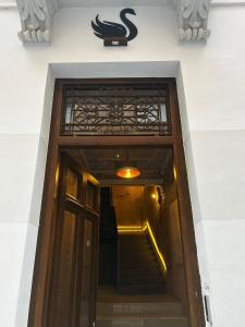 a door to a building with a sign above it at Black Swan Hostel Granada in Granada