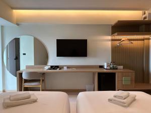 um quarto com uma secretária e uma televisão na parede em Jace hotel em Banguecoque