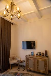 Boutique ETHNO HOTEL في غيومري: غرفة معيشة مع تلفزيون بشاشة مسطحة على الحائط