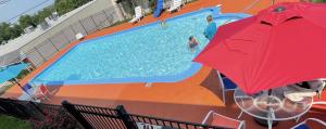 um mural de uma piscina com um guarda-sol vermelho em Days Inn by Wyndham Frankfort em Frankfort