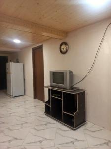 Hostel in Katskhi في Katsʼkhi: غرفة معيشة مع تلفزيون وثلاجة