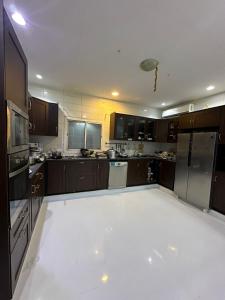 a large kitchen with brown cabinets and a white floor at فيلا سكنية فاخرة in AlUla