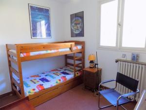 1 dormitorio con litera y silla en Large family house close to the beach en Les Mathes