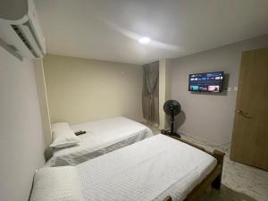 サンタ・マルタにあるVilla Carolina SMのベッド2台と薄型テレビ付きのベッドルーム +10枚の写真