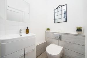 een witte badkamer met een wastafel en een toilet bij Best Covent Garden/Chinatown/Soho Location in Londen